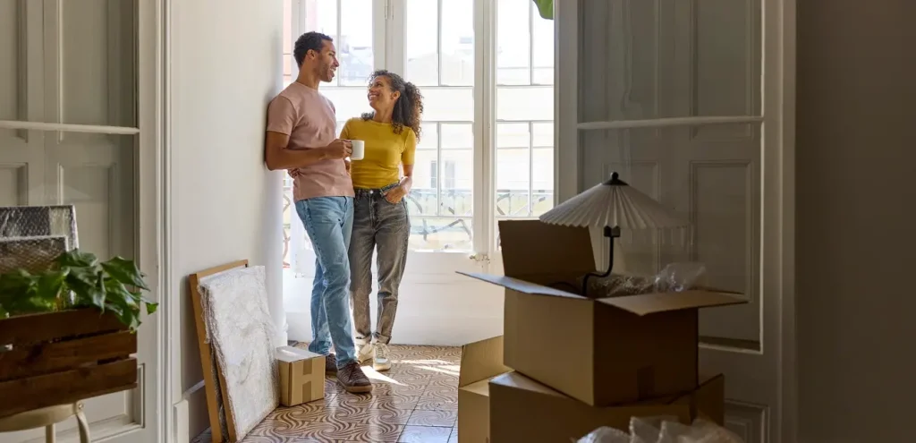 A happy young couple standing in their new home.